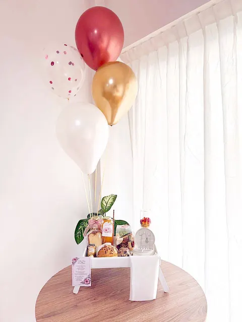 Desayuno sobre mesa ratona con globos cromados
